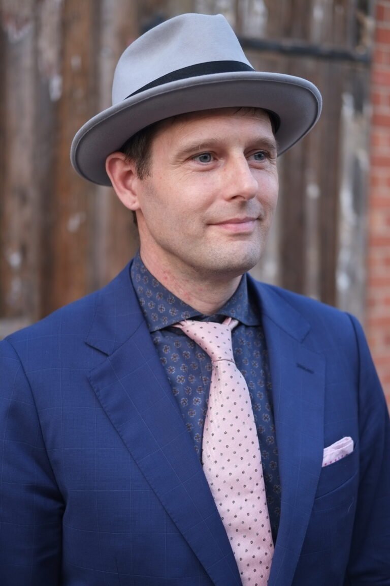 Professional headshot of corporate magician Shaun wearing a blue suit